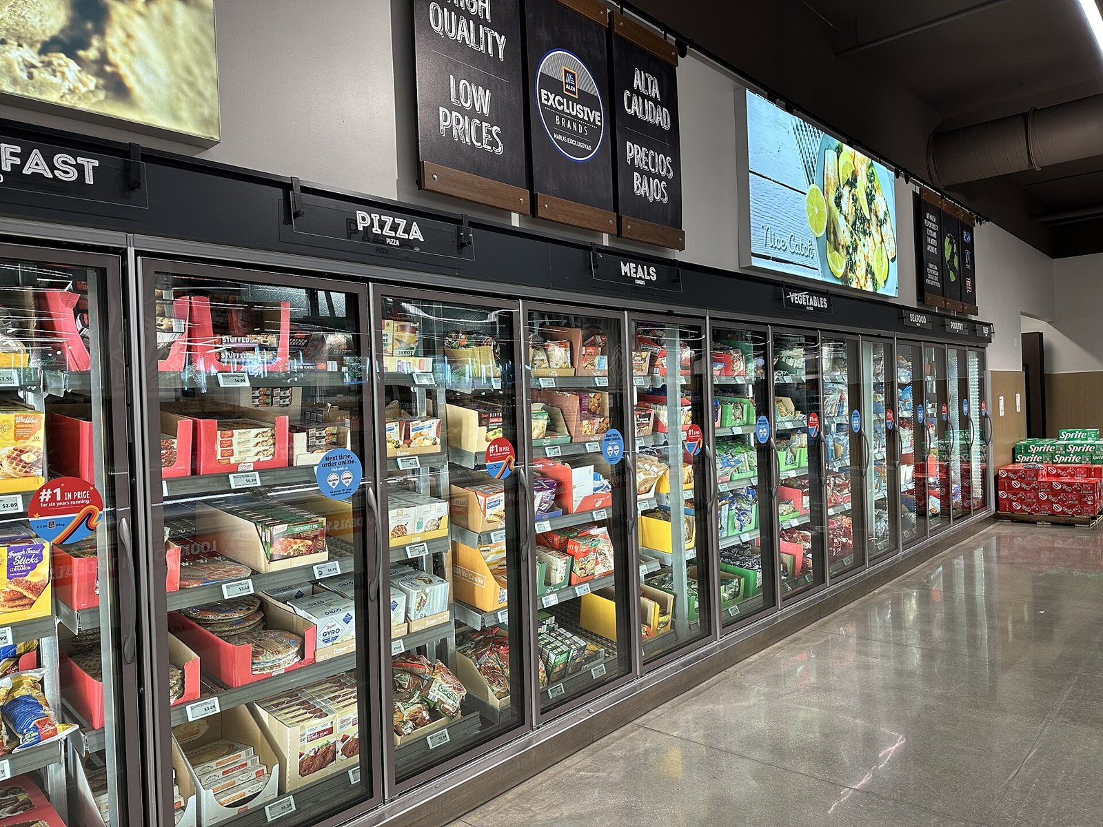 Supermarket freezer aisle with glass-door refrigerated display cases holding frozen food