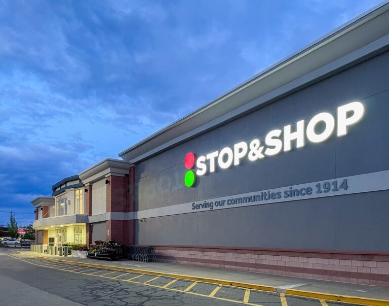 Exterior of a Stop & Shop supermarket at dusk, one of Ahold Delhaize USA's grocery banners
