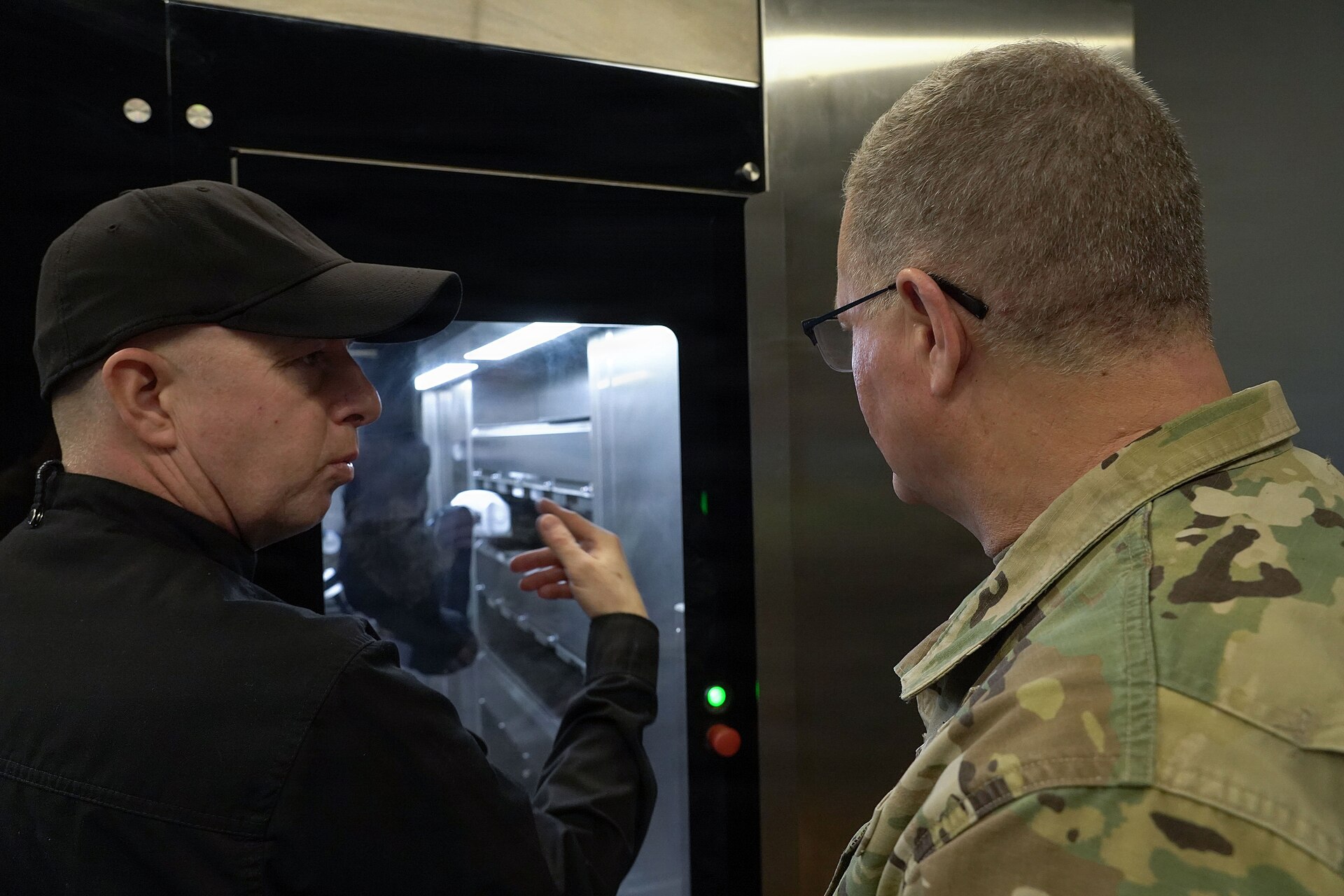 Visitors observing an autonomous robotic kitchen system during a demonstration walkthrough