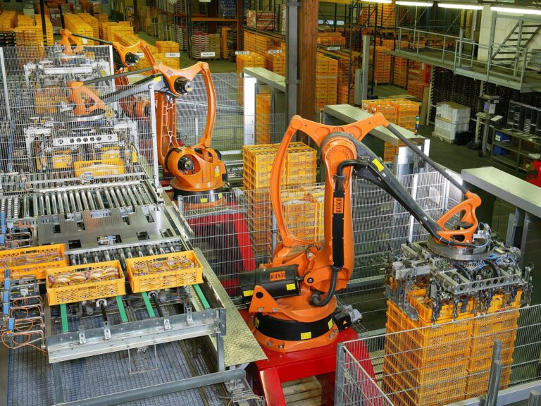 Orange industrial robots palletising packaged bread products in an automated bakery