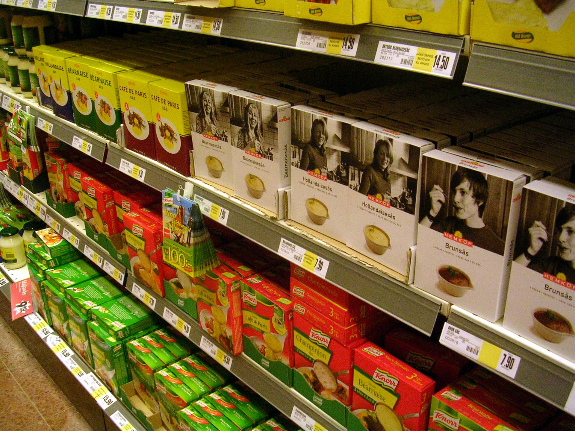 Supermarket shelf displaying private label and branded grocery products in a Swedish Hemköp store